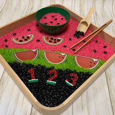 a tray with rice, watermelon slices and blackberries on it next to chopsticks