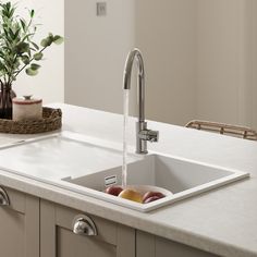 a kitchen sink with a faucet running water from it's spout