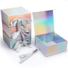 three boxes with white ribbons and bows on the top one box has a bow in it