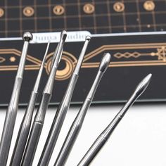 a group of metal pens sitting on top of a white table next to a black box