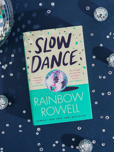 a book sitting on top of a blue table covered in confetti and disco balls