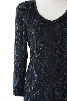 "Stunning Vintage 1980s black heavily beaded + sequin Silk mini dress Deco motif Deep V bodice long sleeve ultra sliming fit 100% silk Great Vintage condition M e a s u r e m e n t s: Size: Vintage Size 4 - fit like a S M BUST: 18\" Waist: 15\" Hips: 18 1/2\" Total Length: 36\" Label: Nite Line Fabric: 100% Silk Sleeves: 23 1/2\" +All Measurements are taking while garment is lying flat + + Jewelry, belts, and any other accessories are NOT included unless specifically stated in description + i n Black Fitted Long Sleeve Sequin Dress, Fitted Sequin Dress For Formal Winter Events, Fitted Sequin Dress For Winter Formal, Fitted Long Sleeve Sequin Dress For Winter, Black Long Sleeve Sequin Dress For Winter, Holiday Long Sleeve Mini Evening Dress, Long Sleeve Sequined Mini Dress For Gala, Winter Evening Fitted Sequin Dress, Sequined Long Sleeve Mini Evening Dress