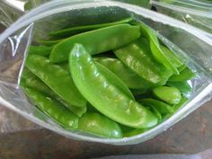 some green beans are in a plastic container