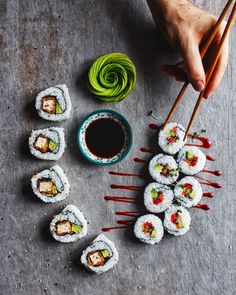 sushi with chopsticks and sauce on the table