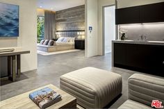 a living room filled with furniture and a flat screen tv mounted to the wall next to a kitchen