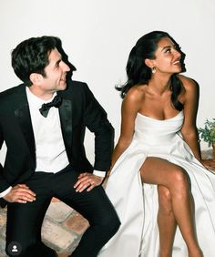 a man in a tuxedo sitting next to a woman in a white dress