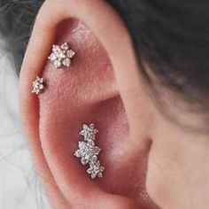 a woman's ear with three small stars on it