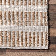 a white and brown rug sitting on top of a wooden floor