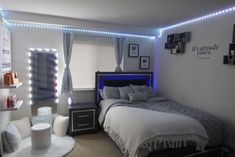 a bed room with a neatly made bed and some lights on the wall above it