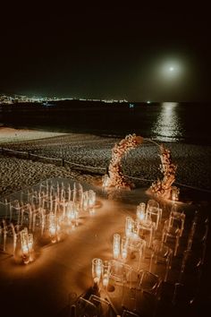 an outdoor ceremony set up on the beach at night