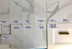 white marble tiles with different types of labels on them and magnets attached to the wall