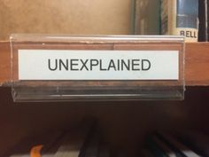 an unexplained sign on a shelf in a library