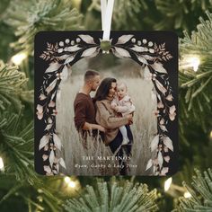 an ornament hanging on a christmas tree with the image of a couple and their child