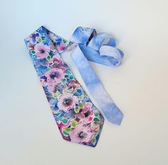 This tie is in hand-painted floral silk I drew small garden flowers with transparent gutta which I painted in soft colors on a pastel blue background. * silk * 9.5cm x 140cm * Floral pattern * High quality French paintings *Heat fixed to preserve colors * Made in Lyon * pastel blue, pink, soft green, mauve, purple Gift for wife Wedding Anniversary, Birthdays Gift for dad, Father's Day gift All of my ties are individually hand painted and no two are ever the same. Maintenance : dry cleaning recom Floral Print Tie For Spring Gift, Spring Floral Print Ties As Gifts, Floral Print Ties For Spring Gift, Adjustable Blue Floral Print Tie, Blue Ties For Summer Gift, Blue Tie For Summer As A Gift, Blue Tie For Summer Gift, Blue Ties As Summer Gift, Blue Floral Print Tie As Gift