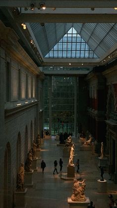 the inside of a museum with many statues on display