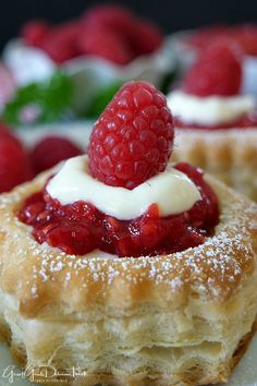 raspberry and cream filled pastry with fresh berries on the side for garnish