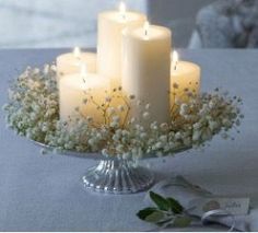 candles are lit on a table with flowers