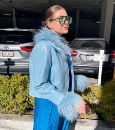 a woman wearing sunglasses and a blue coat