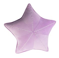 a purple star shaped pillow sitting on top of a white wall