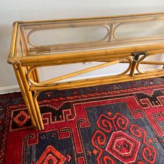 a bamboo bench sitting on top of a rug