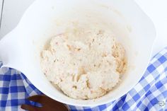 a white bowl filled with food on top of a blue and white checkered table cloth