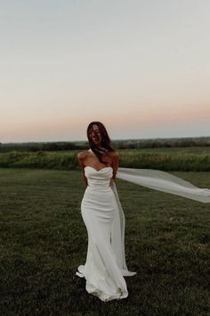 a woman in a white wedding dress holding a veil