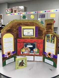 an open book on a table in front of a display case with pictures and writing