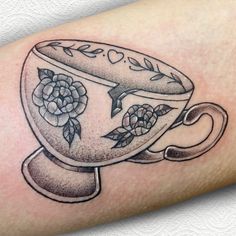 a black and white drawing of a teacup with roses on it's side