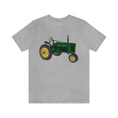 This tractor is styled after a John Deere H, one of the many tractors that my dad has.  This shirt is for every John Deere buff, farmer and tractor person out there! This classic unisex jersey short sleeve tee fits like a well-loved favorite. * 100% combed and ring-spun cotton (Heather colors contain polyester) * Pre-shrunk fabric * Side-seamed construction * Shoulder-to-shoulder taping * Unisex sizing.  I typically wear a Woman's Large (10-12). In this shirt I like a Medium for a regular fit or Large for a loose, comfy fit. * Bella Canvas Brand shirt. Slight shrinkage on length after washing. We Ride At Dawn, Tee Shorts, Happy Hippie, Custom Drawing, Hand Drawn Design, Branded Shirts, Unisex Tshirt, Comfy Fits, John Deere