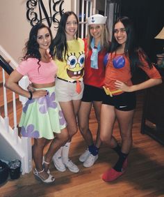 four girls dressed up in costumes posing for the camera