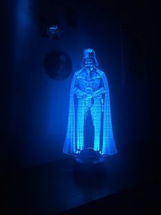 a blue light - up star wars figure is shown in the middle of a dark room