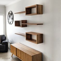 a living room filled with furniture next to a wall mounted clock on the side of a white wall