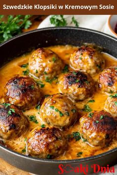 some meatballs and sauce in a pan with parsley on the side for garnish