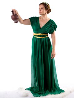 a woman in a long green dress holding a jug and wearing a gold belt around her waist