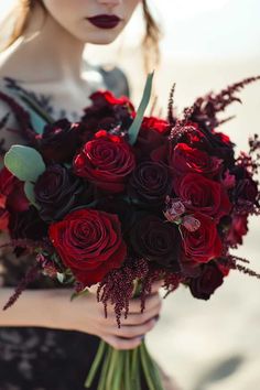 a woman holding a bouquet of red roses