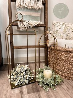 a candle sits on the floor next to a basket with greenery and candlesticks