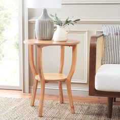 a small table with a vase on it next to a chair