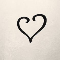 a heart drawn on the side of a white wall with black ink in it's center