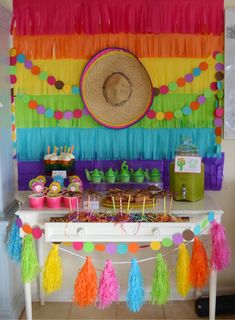 a table topped with lots of tassels next to a wall covered in colorful decorations