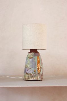 a lamp sitting on top of a white shelf