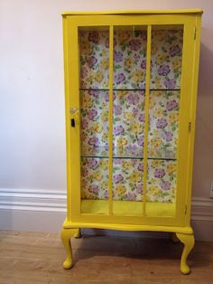 a yellow china cabinet with flowers on it