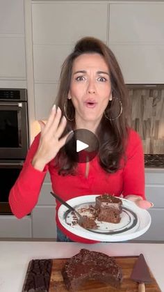 a woman is holding a plate with some food on it in front of her face