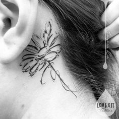 a woman with a tattoo on her neck and behind the ear is a dandelion