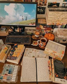 an open book sitting on top of a wooden desk next to a computer monitor and keyboard