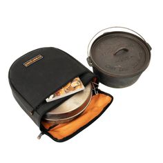 an outdoor pot and pan are sitting on the back of a black backpack with orange linings