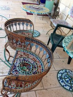 several chairs and tables with mosaic designs on them