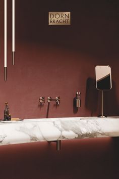 a bathroom sink with two faucets and soap dispensers on the wall