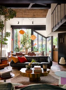 a living room filled with lots of furniture and plants on top of it's tables