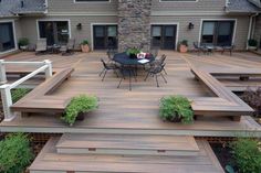 a patio with wooden steps leading up to a table and chairs on top of it