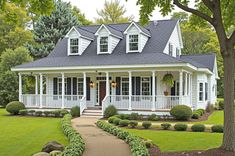 a white house with black roof and front porch